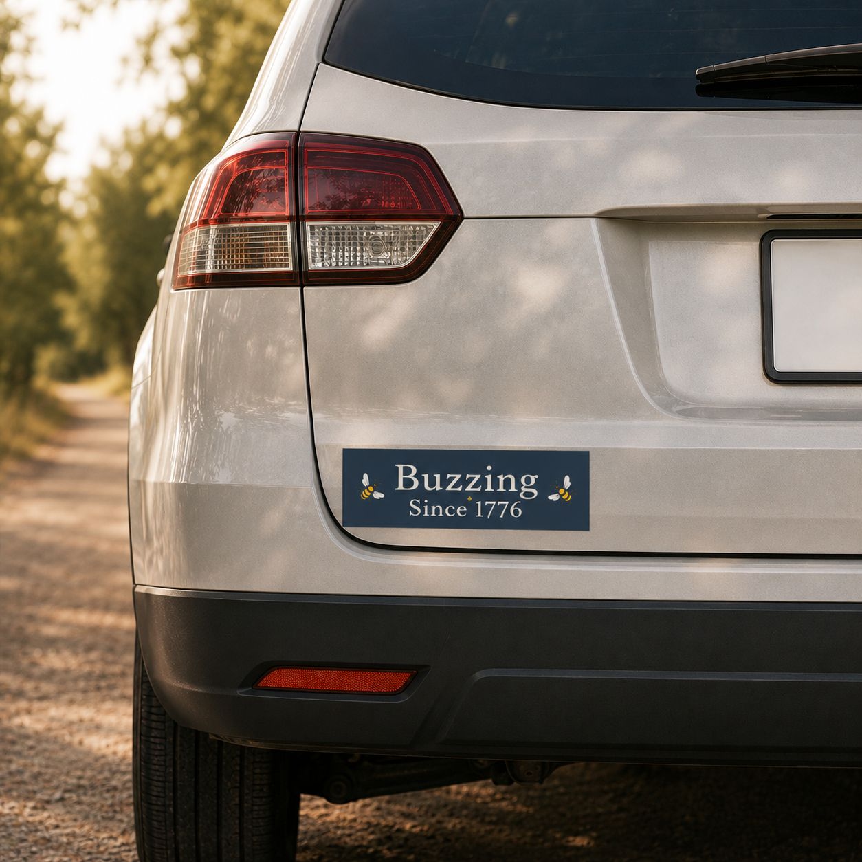 Rectangle bumper sticker on rear of a car: 'Buzzing Since 1776' with bee icons