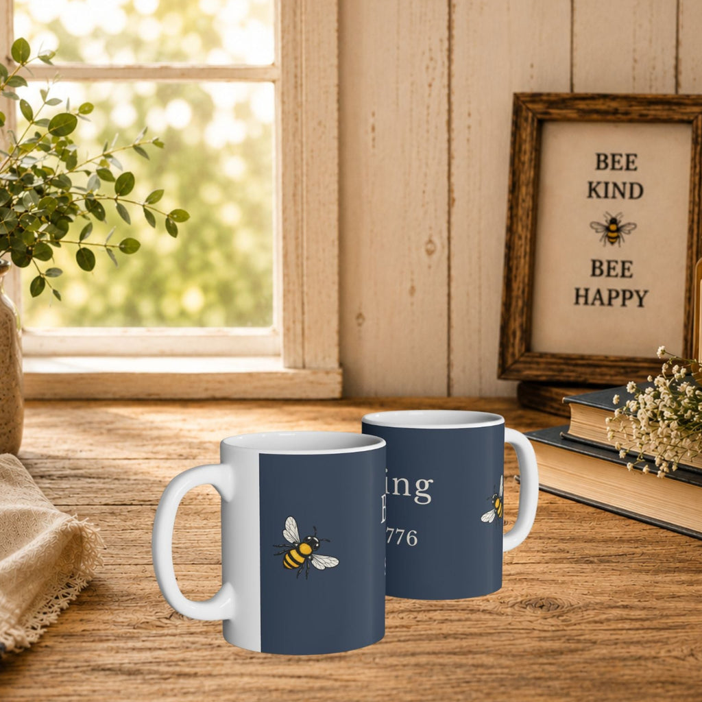 Two navy ceramic mugs with bee design on a wooden table
