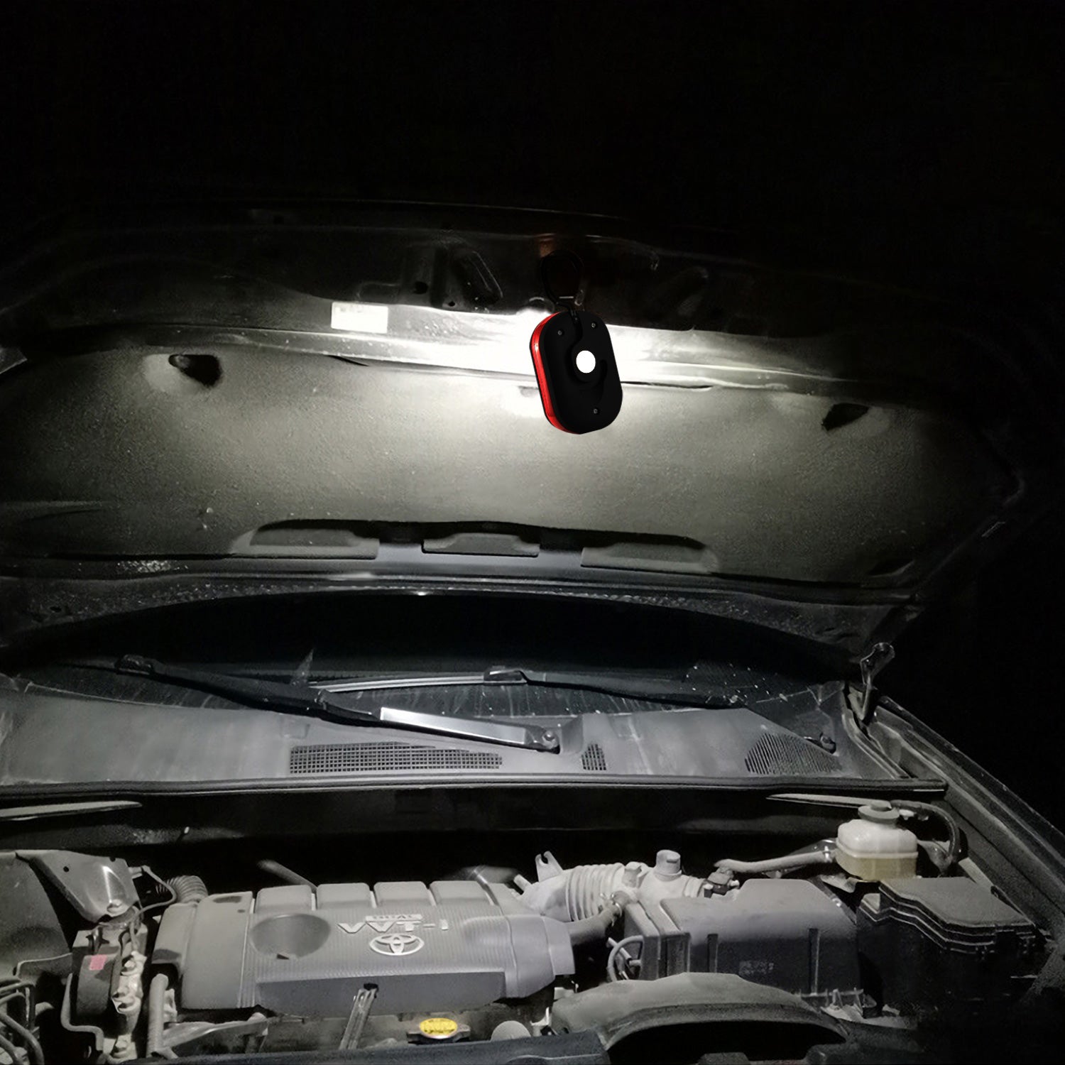 LED work light mounted under a car hood, red and black casing with white LEDs