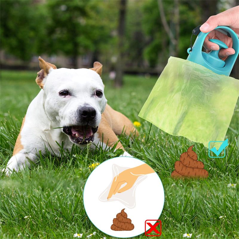 Dog poop scooper kit held with green bags over a dog in the grass