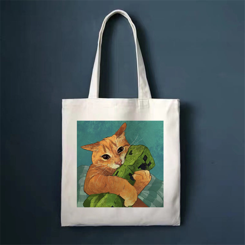 Canvas tote bag, white, with orange cat holding a green book print.