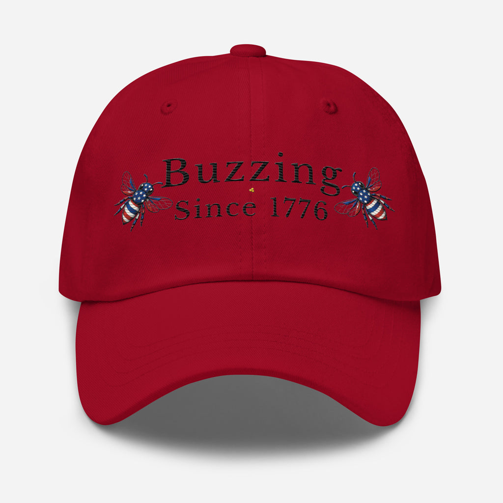 Red dad hat with “Buzzing Since 1776” text and bee graphic embroidery on front