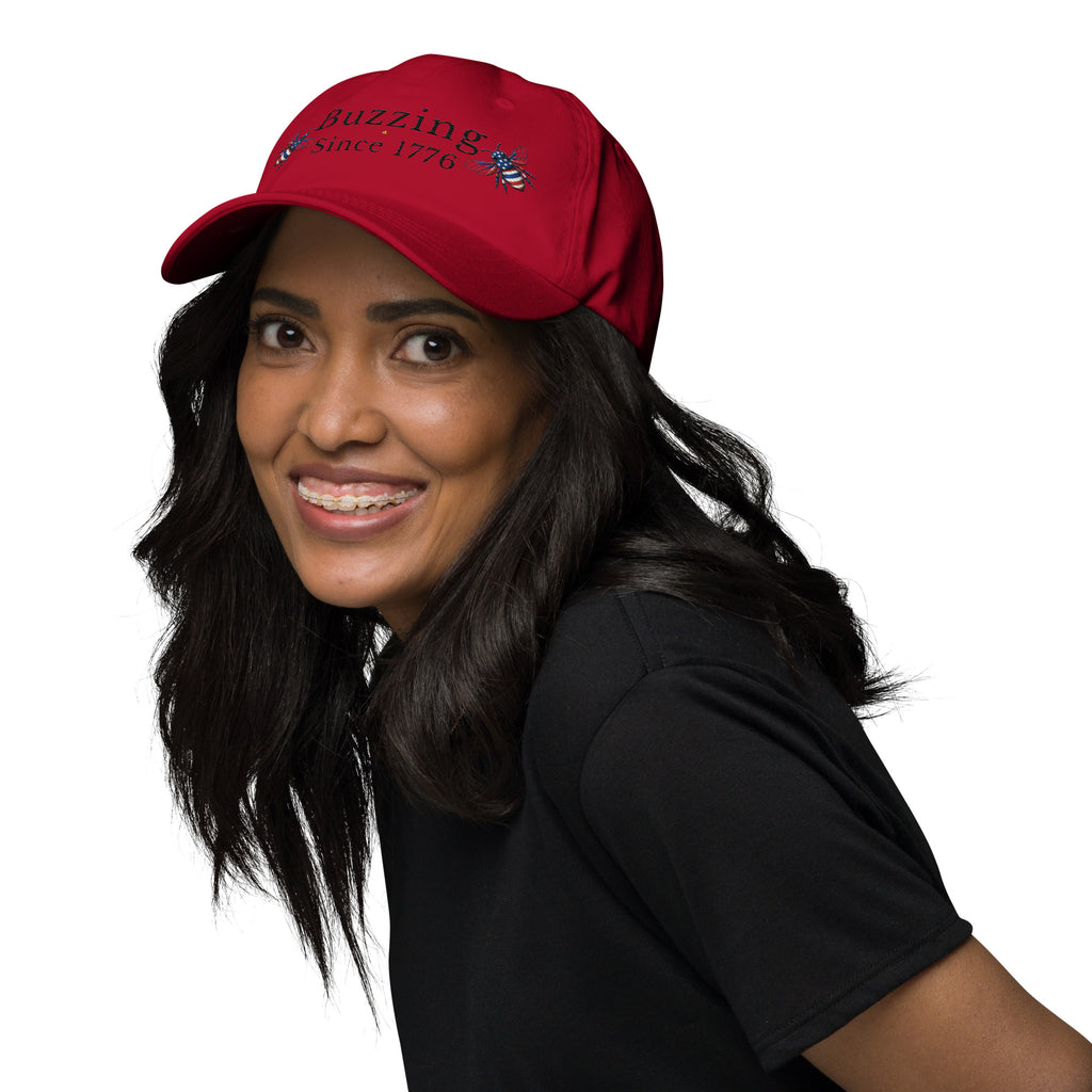 Cranberry dad hat with “Buzzing Since 1776” and bee graphic, worn