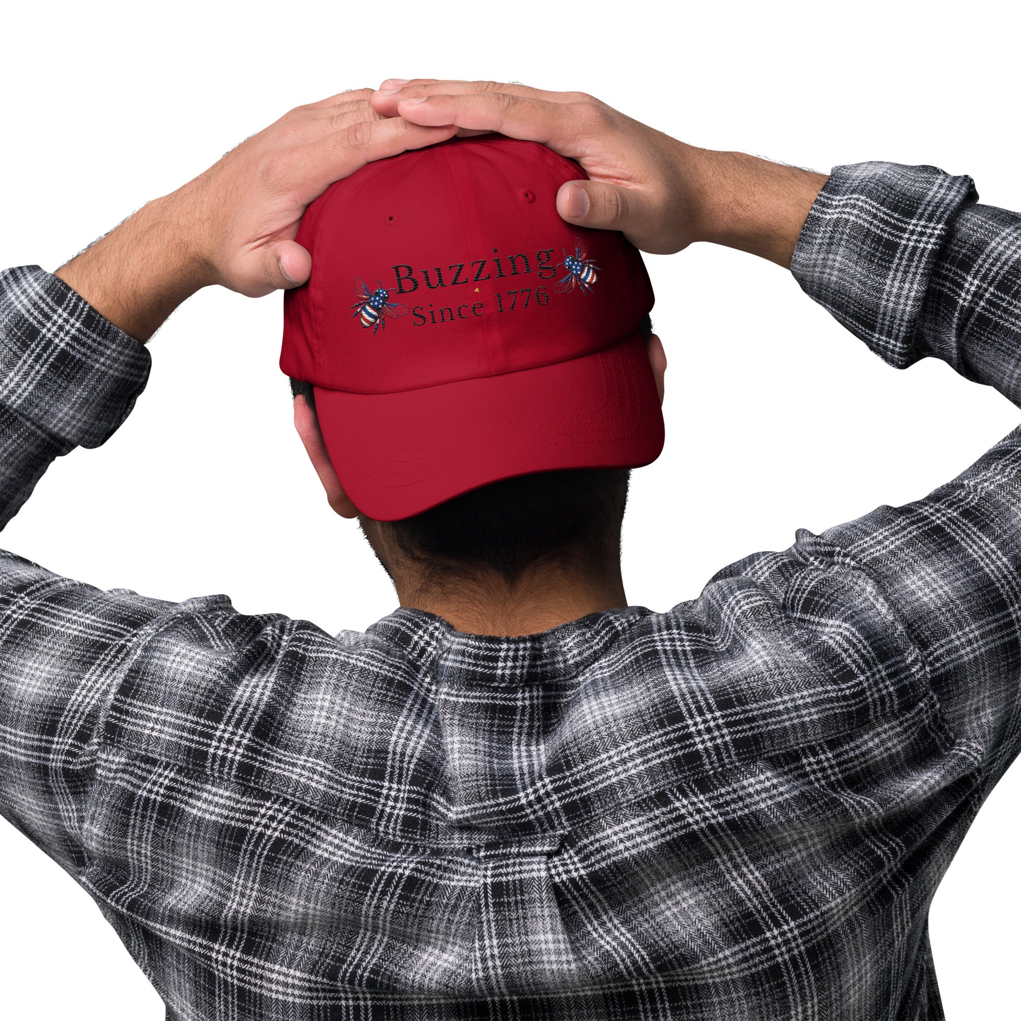 Cranberry red dad hat with embroidered “Buzzing Since 1776” on front