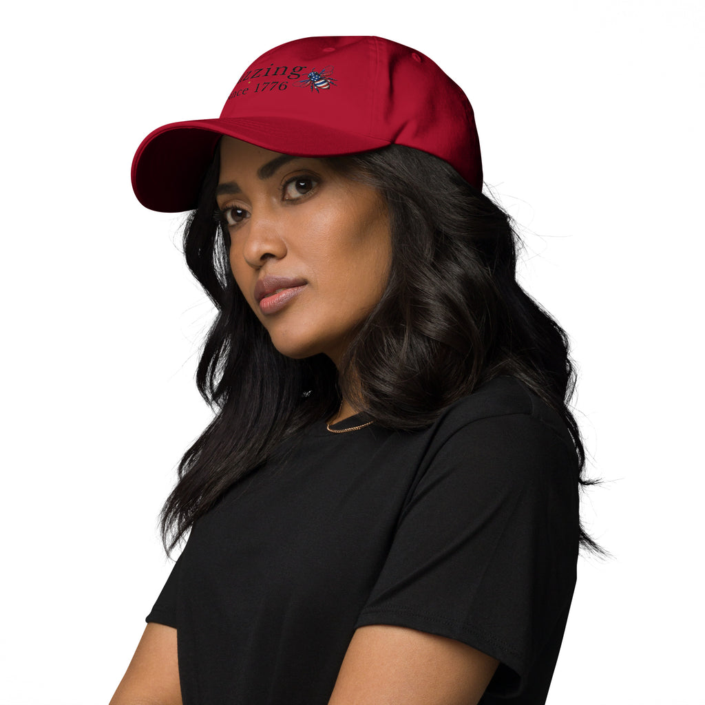 Red dad hat with embroidered text and small bee patch on the front.