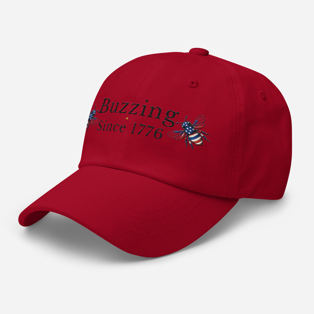Cranberry red dad hat with embroidered bee and Buzzing Since 1776 text