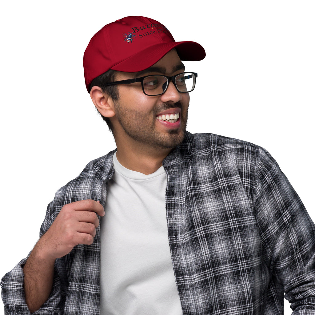 Cranberry red dad hat with embroidered bee and “Buzzing Since 1776” text