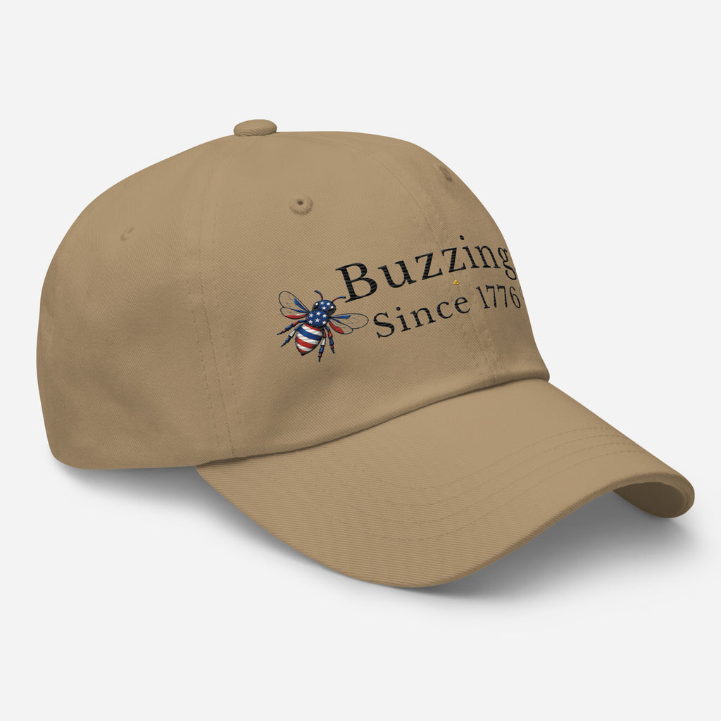 Khaki dad hat with embroidered bee and “Buzzing Since 1776” text on front