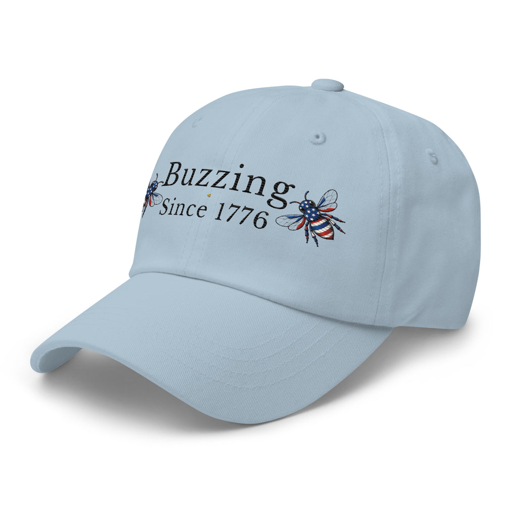 Light blue dad hat with “Buzzing Since 1776” and bee graphic
