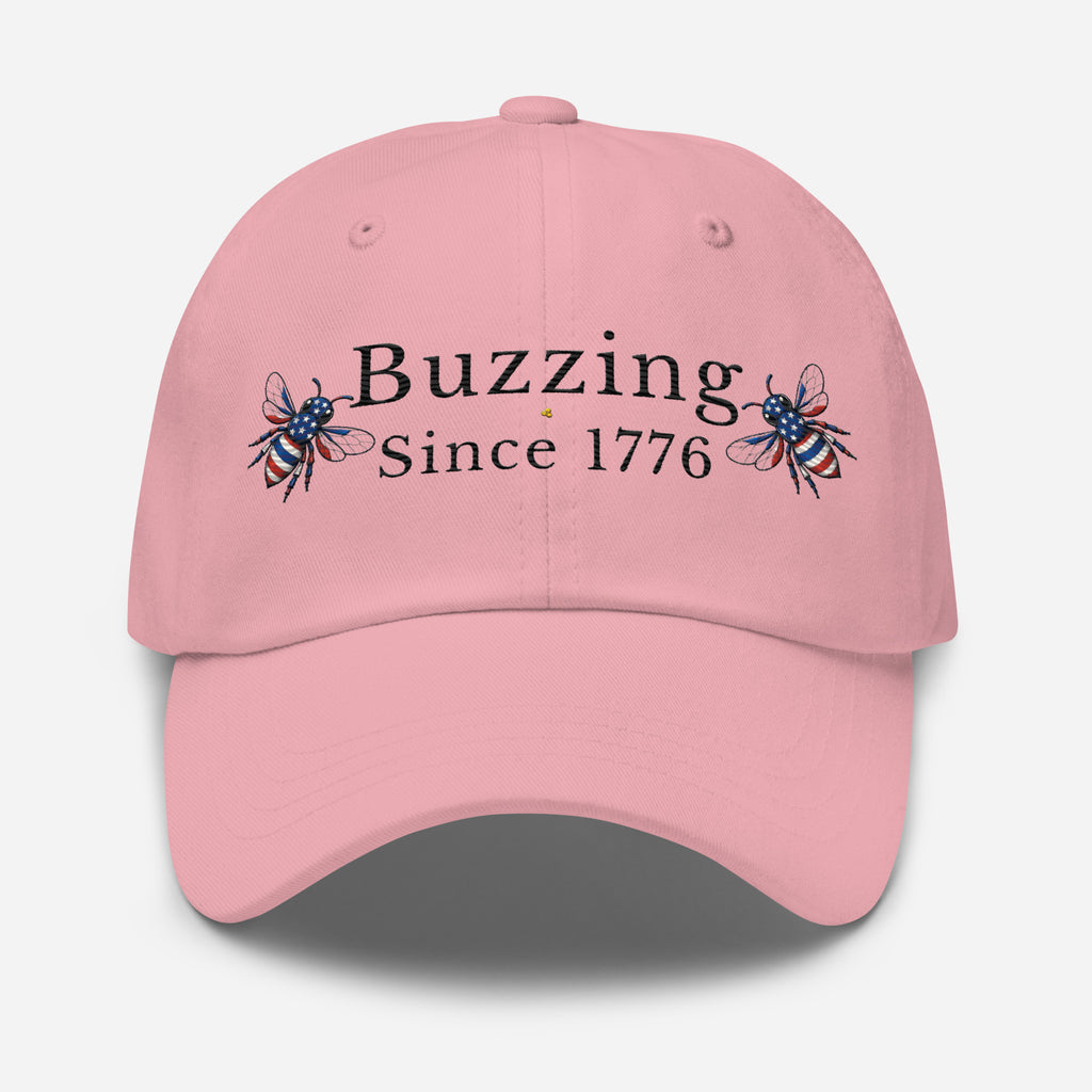 Pink dad hat with “Buzzing Since 1776” text and bee graphic embroidery on front