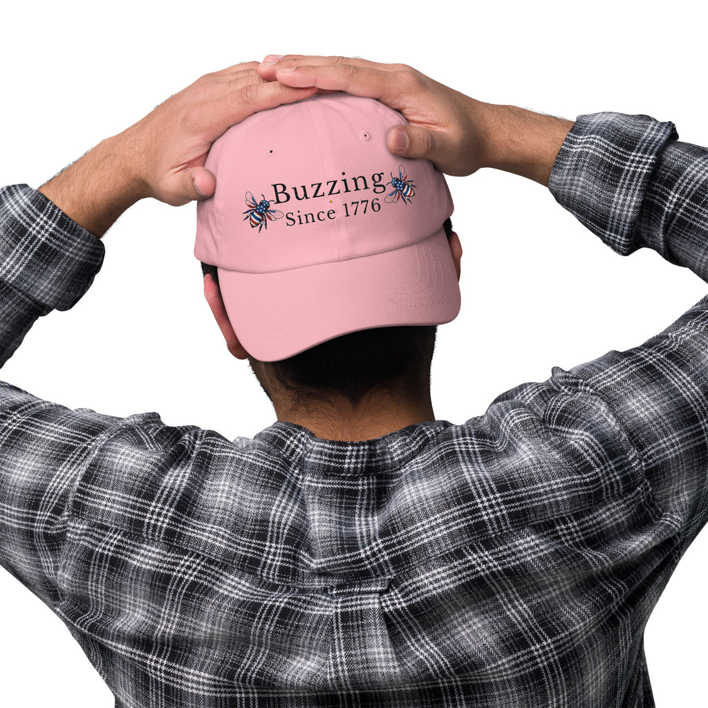 Pink dad hat with embroidered “Buzzing Since 1776” on back