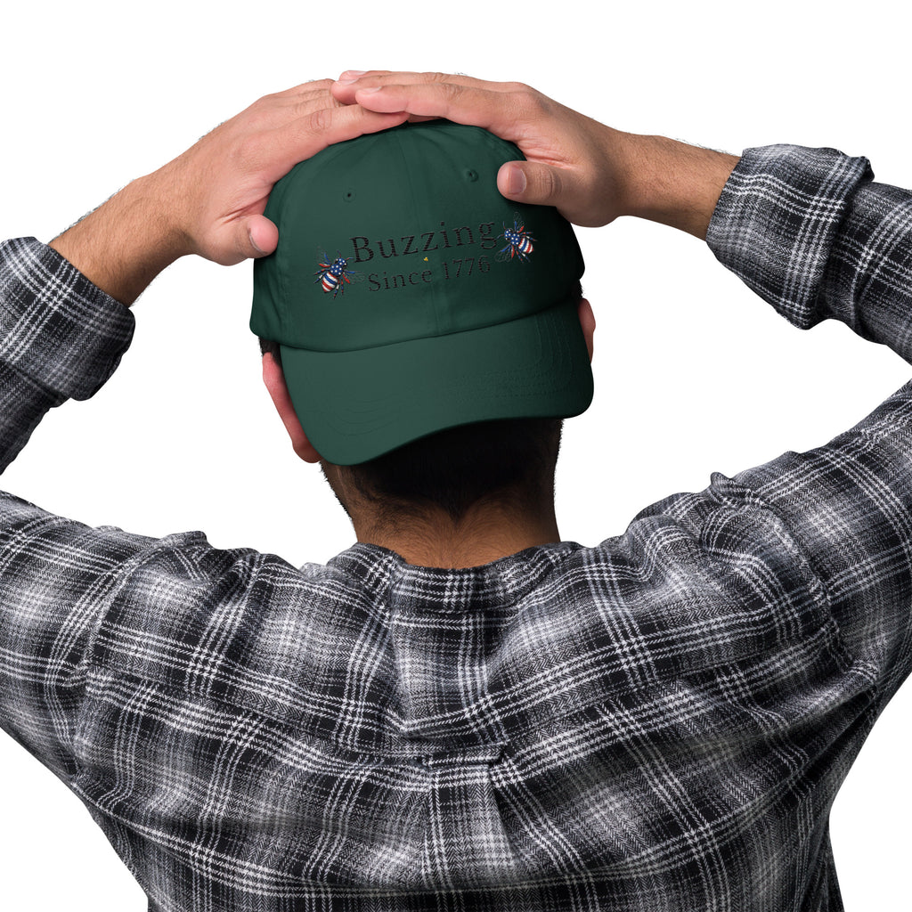 Spruce green dad hat with embroidered “Buzzing Since 1776” on front