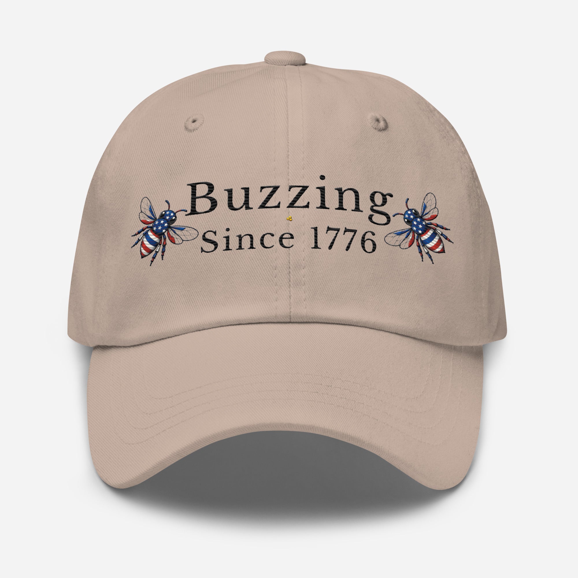 Stone dad hat with “Buzzing Since 1776” text and bee graphic embroidery on front