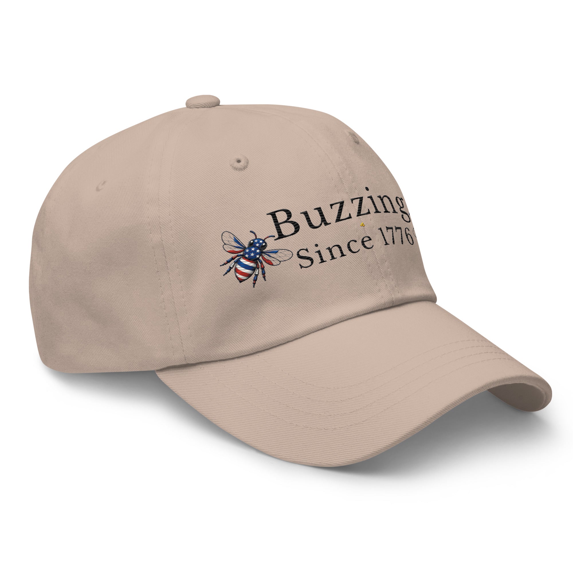 Stone beige dad hat with “Buzzing Since 1776” and a bee logo on front