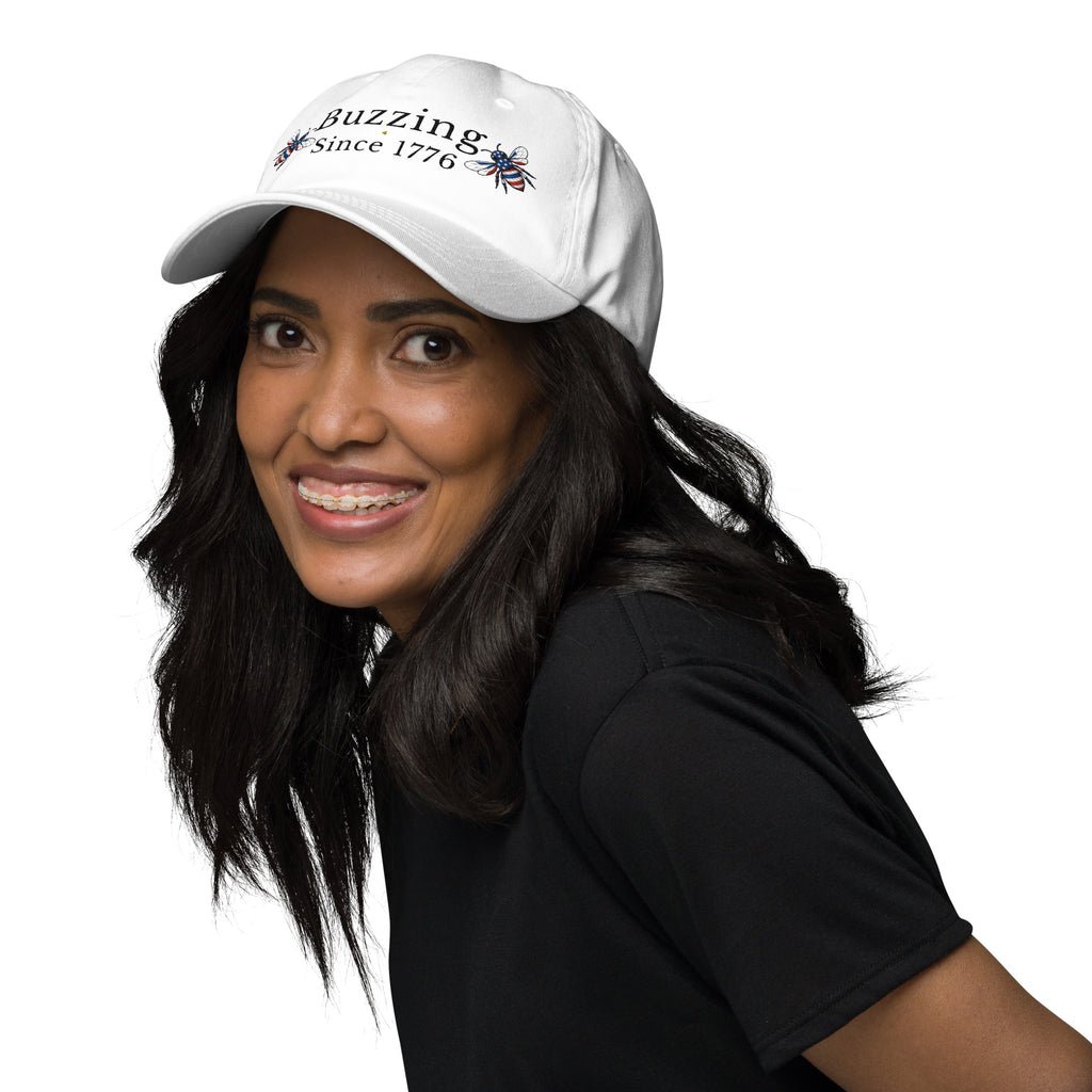 White dad hat with embroidered text and small bee patch on the front.