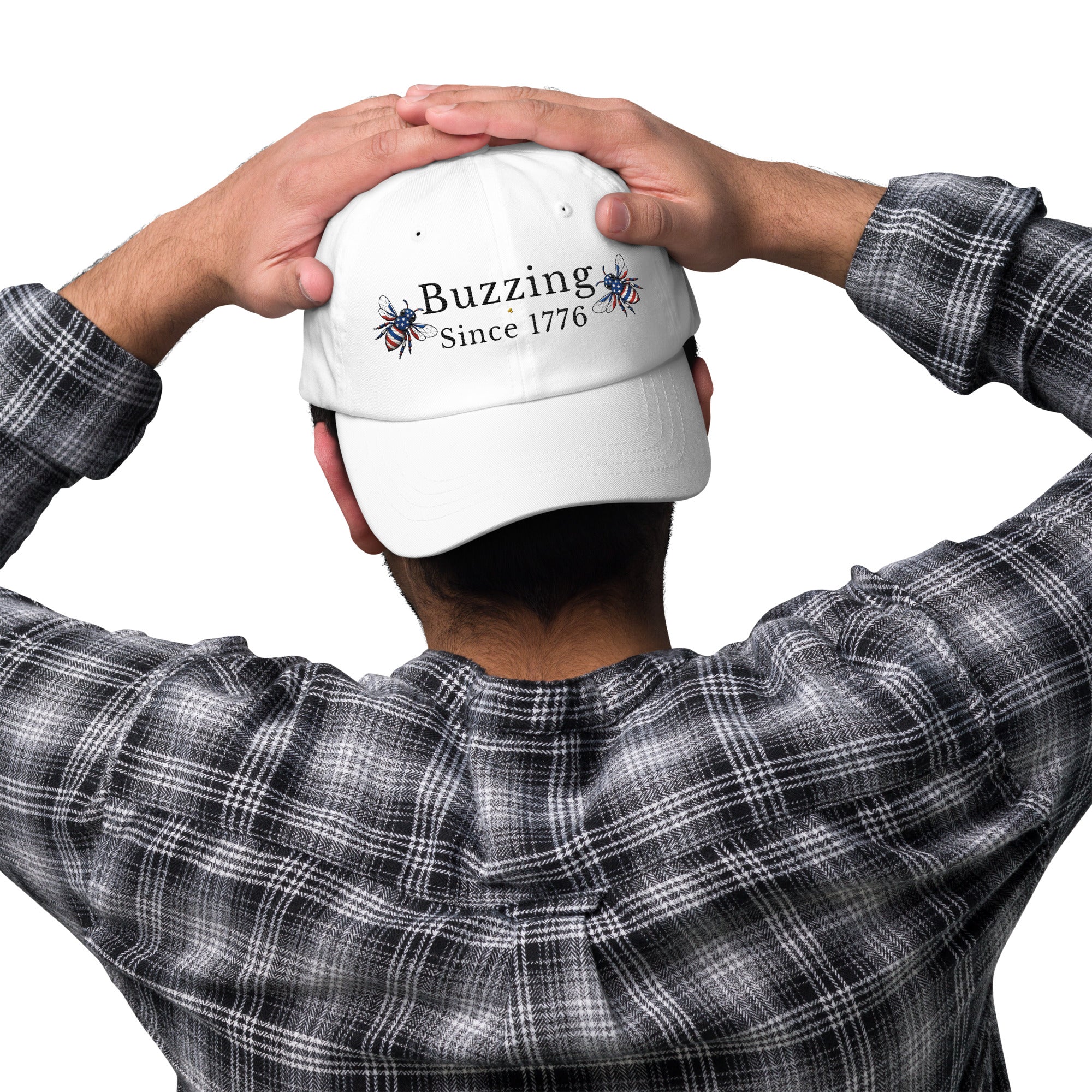 White dad hat with embroidered “Buzzing Since 1776” on back