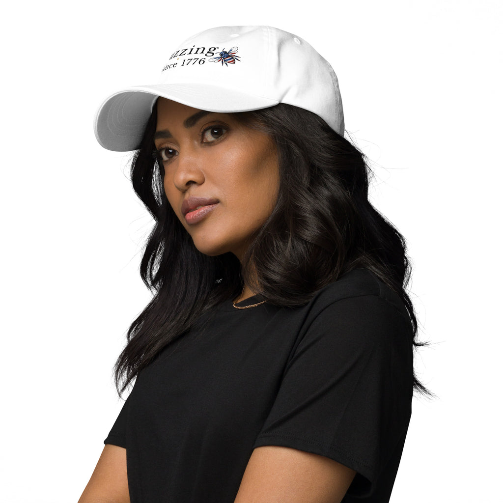 White dad hat with embroidered bee and “Buzzing Since 1776” text