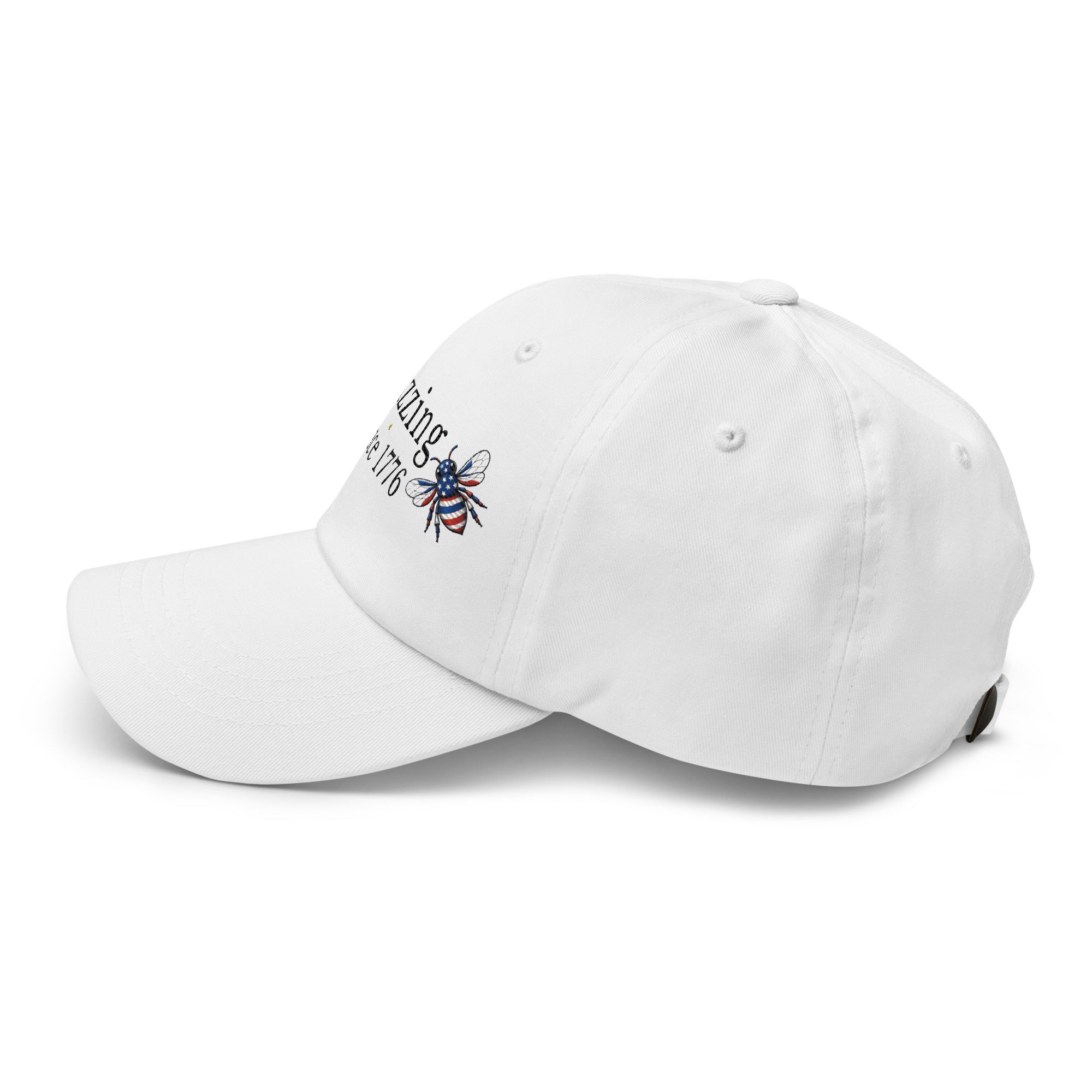 White dad hat with embroidered bee patch and “Buzzing Since 1776” text on front