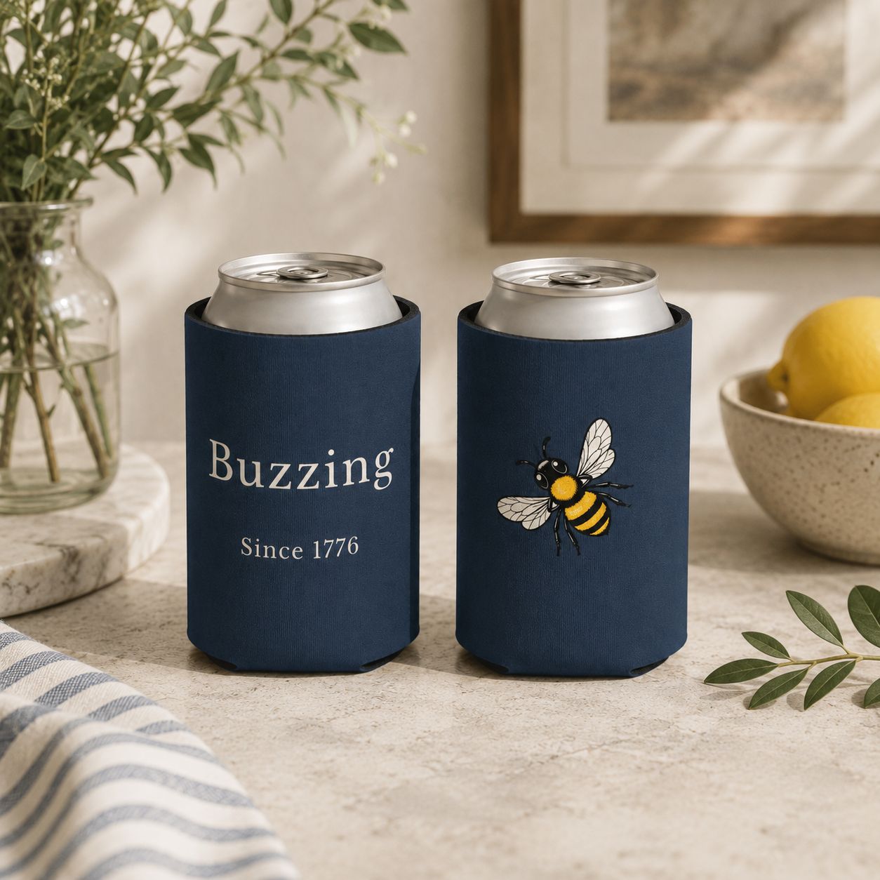 Set of two navy can coolers with 'Buzzing Since 1776' and bee designs