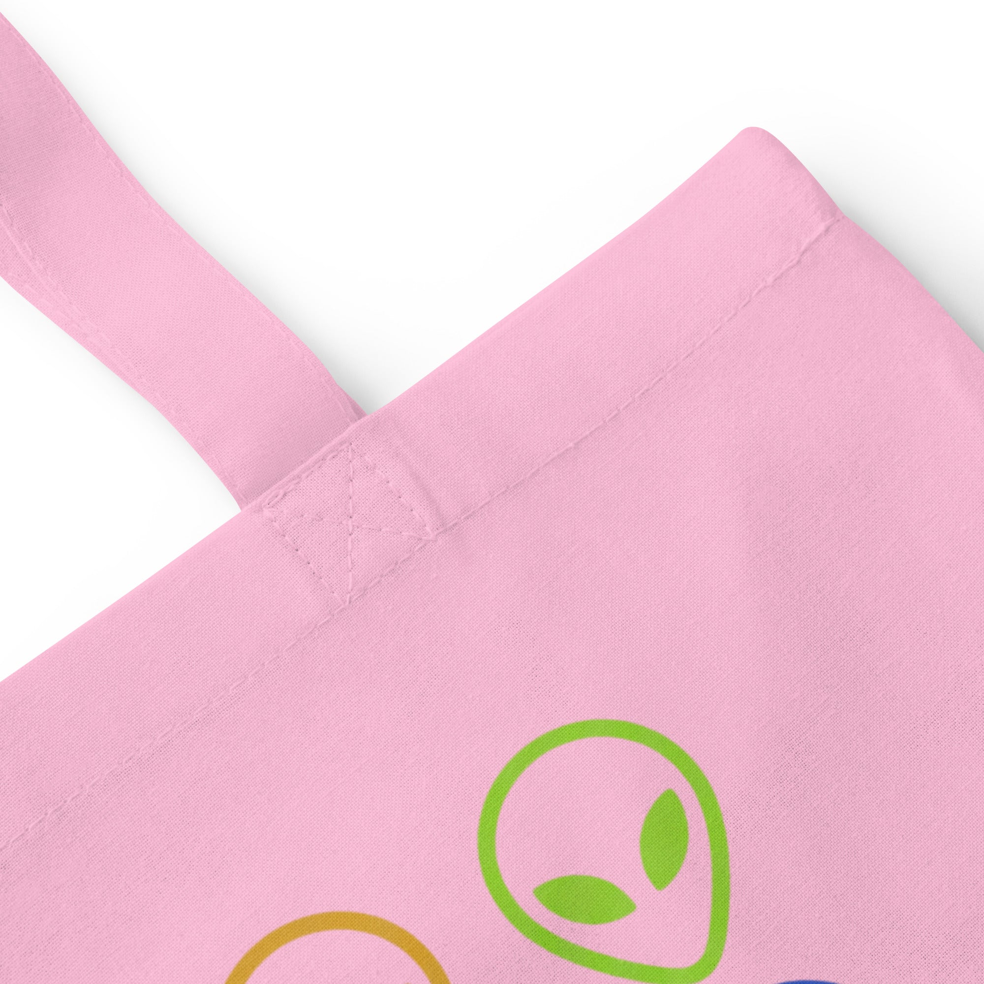 Pink cotton tote bag with alien face graphic patch on front