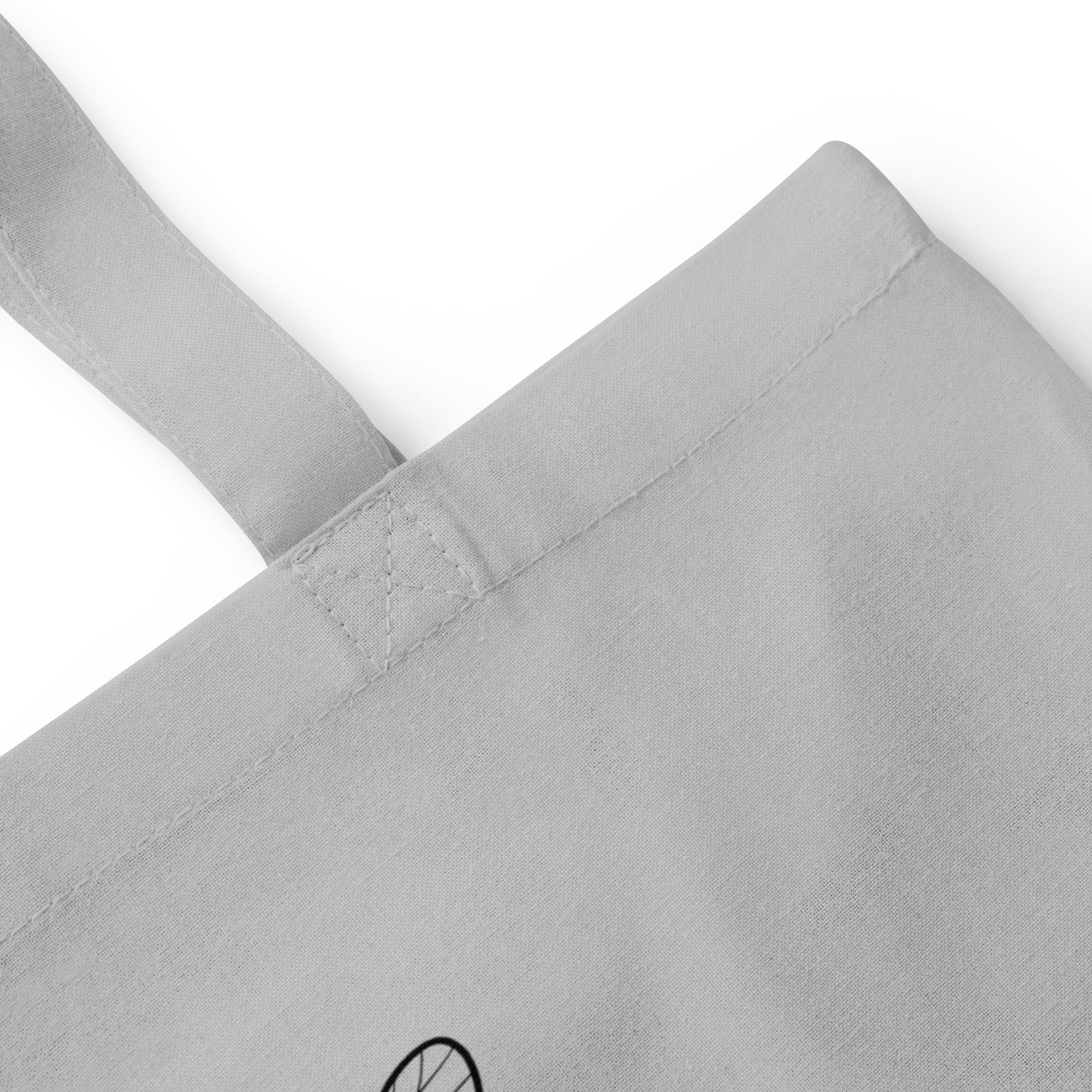 Light grey cotton tote bag close-up of reinforced handle stitching and seam