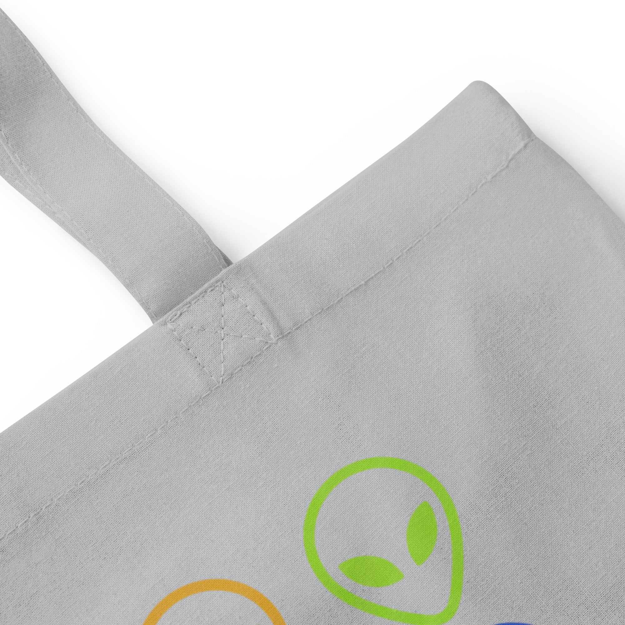 Light gray cotton tote bag with alien face graphic patch on front