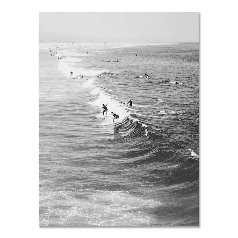 Black-and-white wall poster of surfers riding waves toward the shoreline