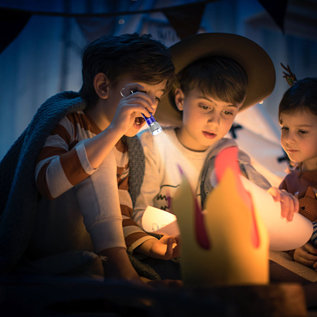 Mini LED keychain flashlight in use, showing bright white light beam