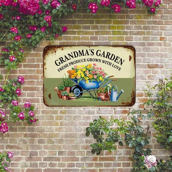 Vintage metal garden sign on brick wall, GRANDMA'S GARDEN text with wheelbarrow floral art