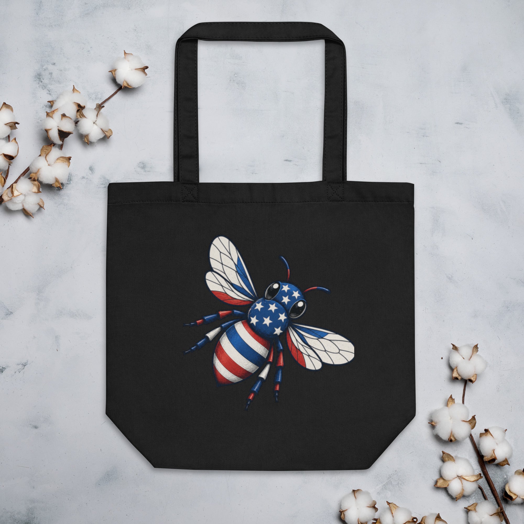 Black tote bag with bee artwork on front, reinforced handles and flat bottom