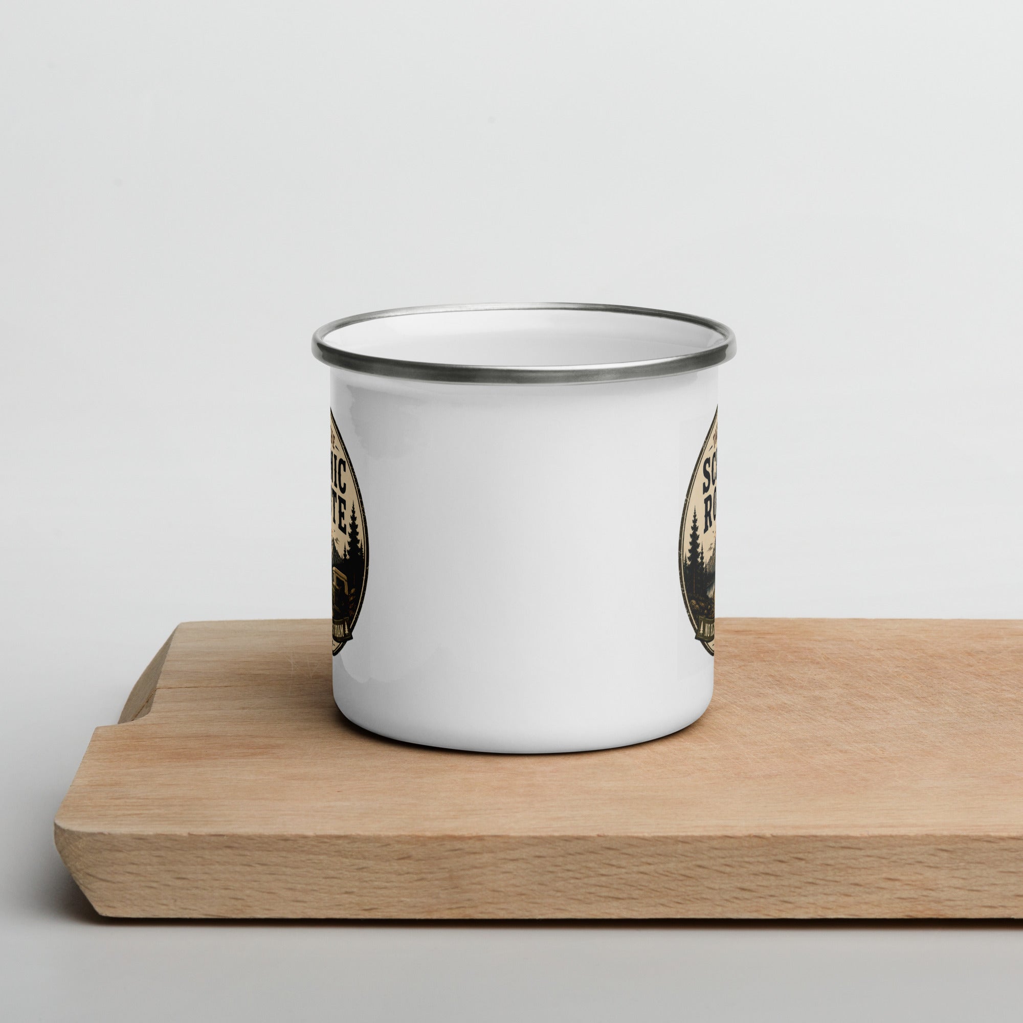 White enamel mug with silver rim, partial Scenic Route graphics visible on sides.