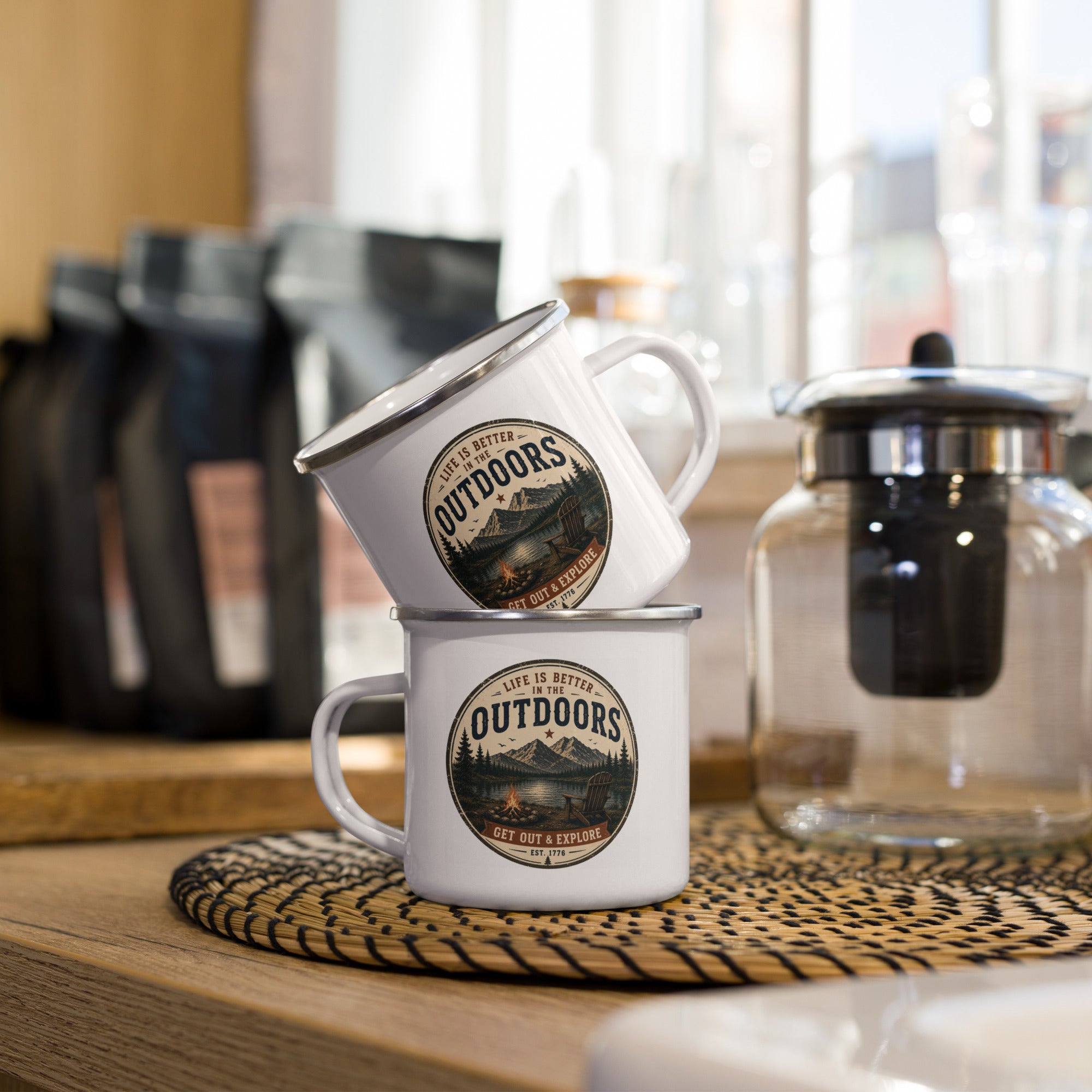 White enamel mug with silver rim, side handle, and Outdoors logo graphic