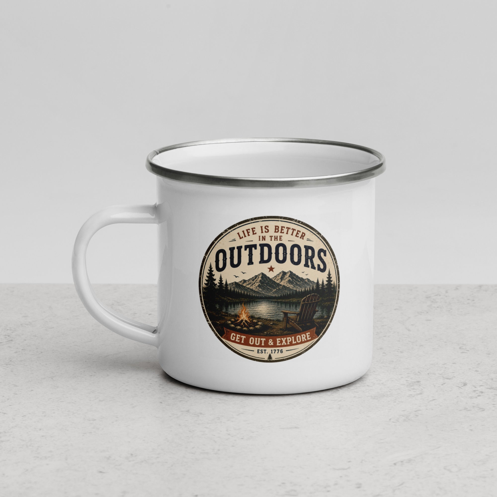 White enamel mug with black rim and front Outdoors badge graphic