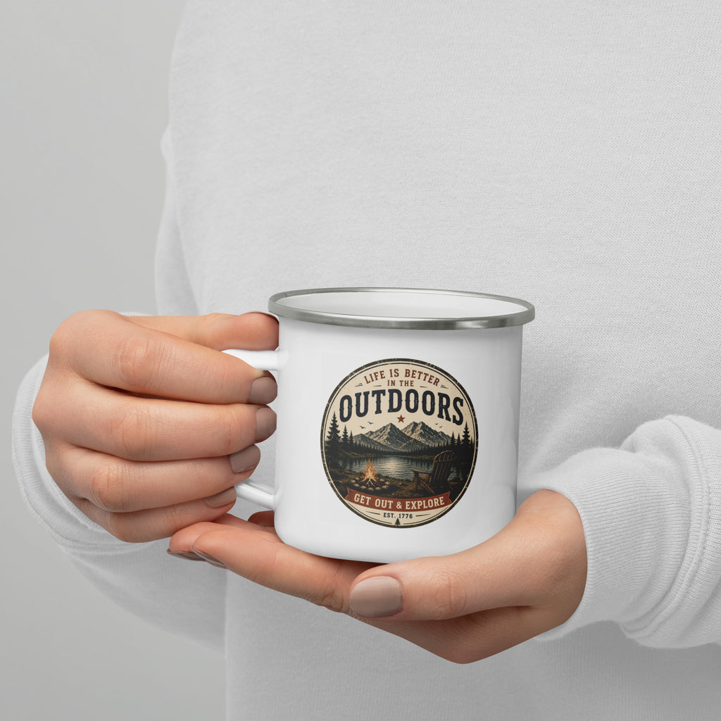 White enamel mug with silver rim held in hands, Outdoors logo visible