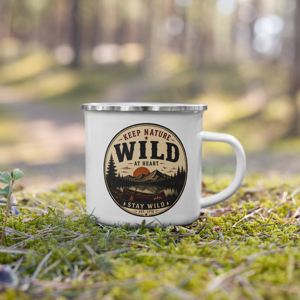 White enamel mug with silver rim and “KEEP NATURE WILD” logo, on grass outdoors.