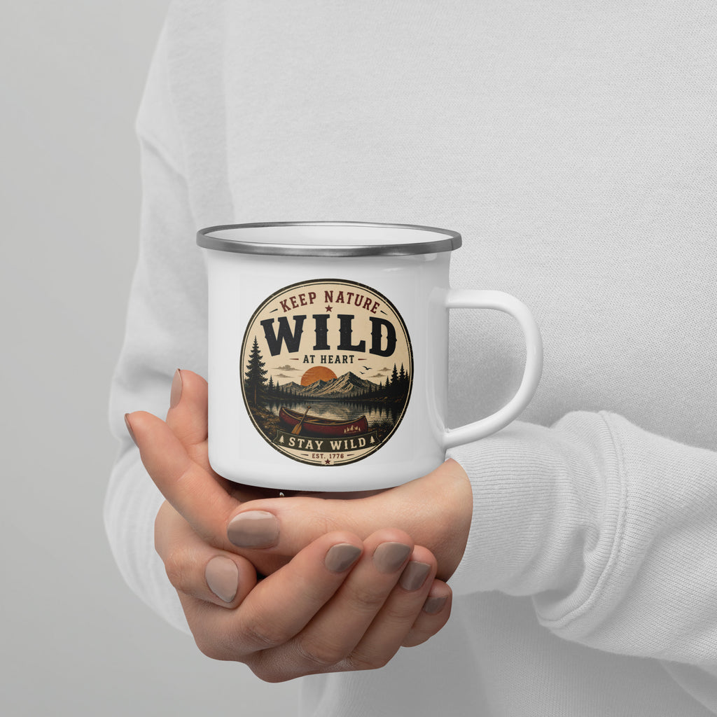 White enamel mug with silver rim and “KEEP NATURE WILD” logo held near chest.