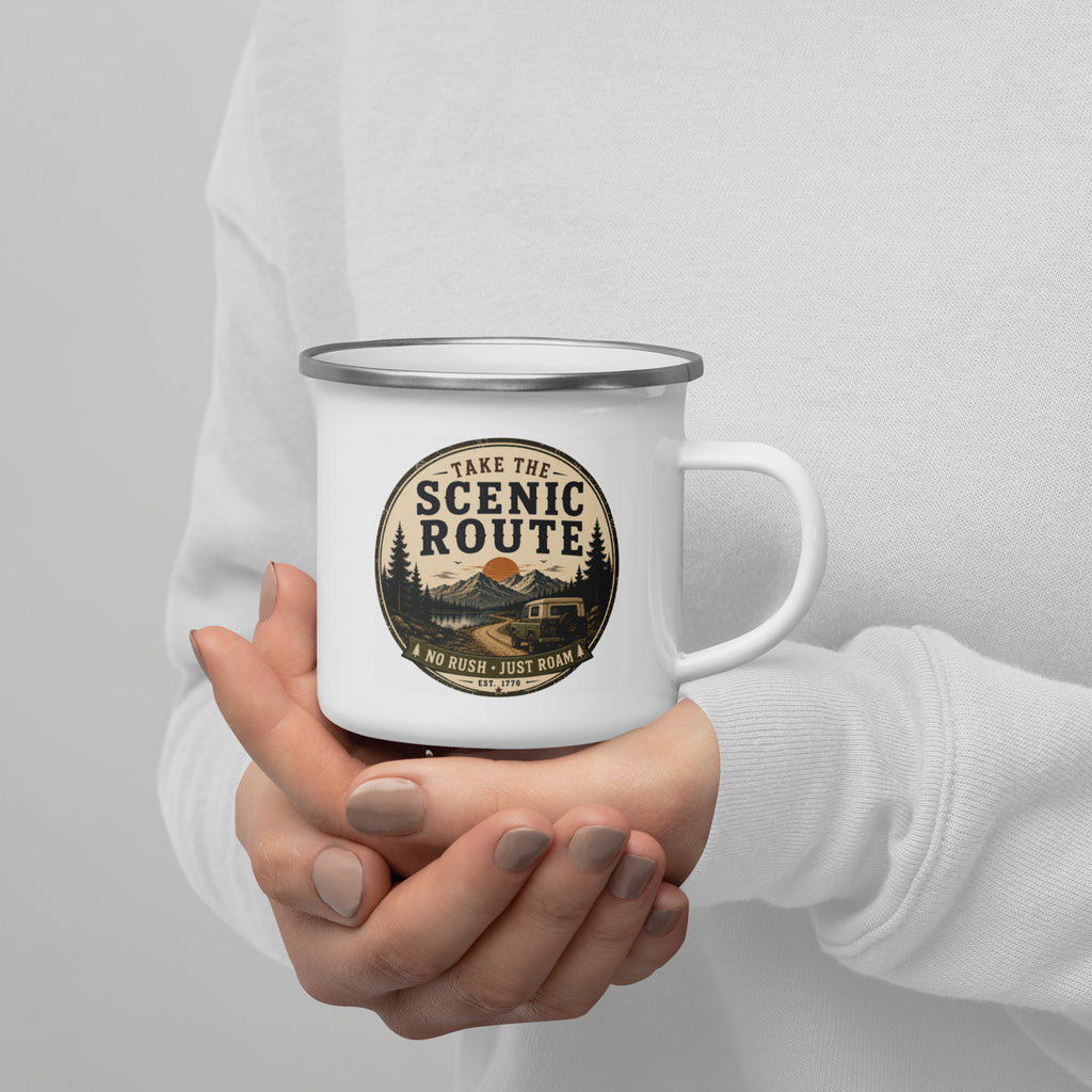 Hands holding a white enamel mug with Scenic Route logo and silver rim