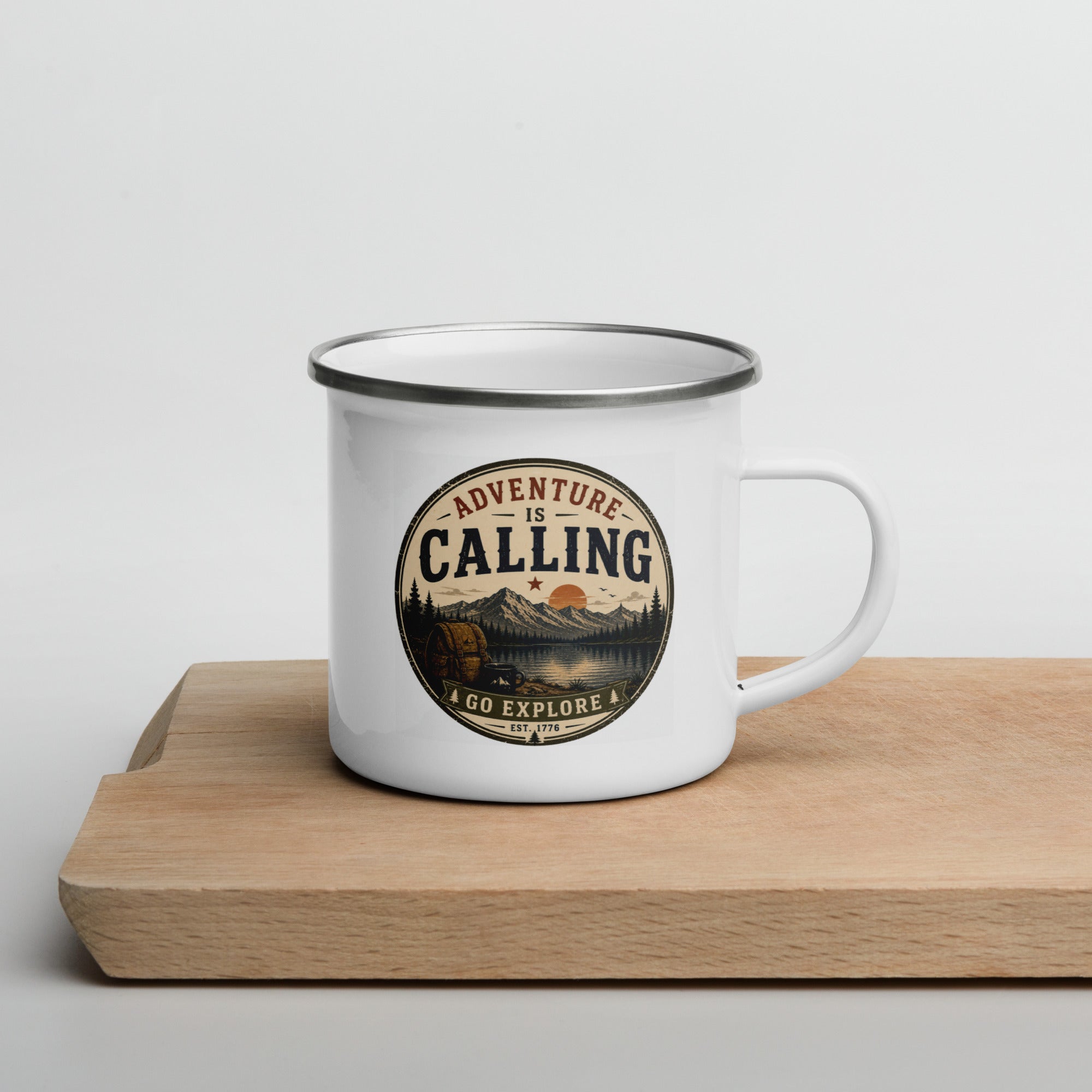 White enamel mug with silver rim and front 'Adventure Is Calling' circular logo