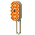 Electric steam pet grooming brush with orange bristle head and light beige handle