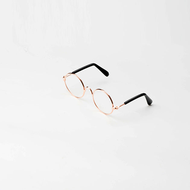 Round pet sunglasses with rose-gold frame and dark tinted lenses, with black side arms