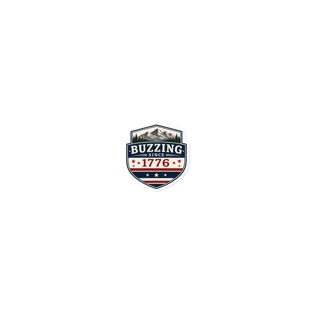Small shield-shaped sticker with 'BUZZING' and 'SINCE 1776' over mountains and stars.