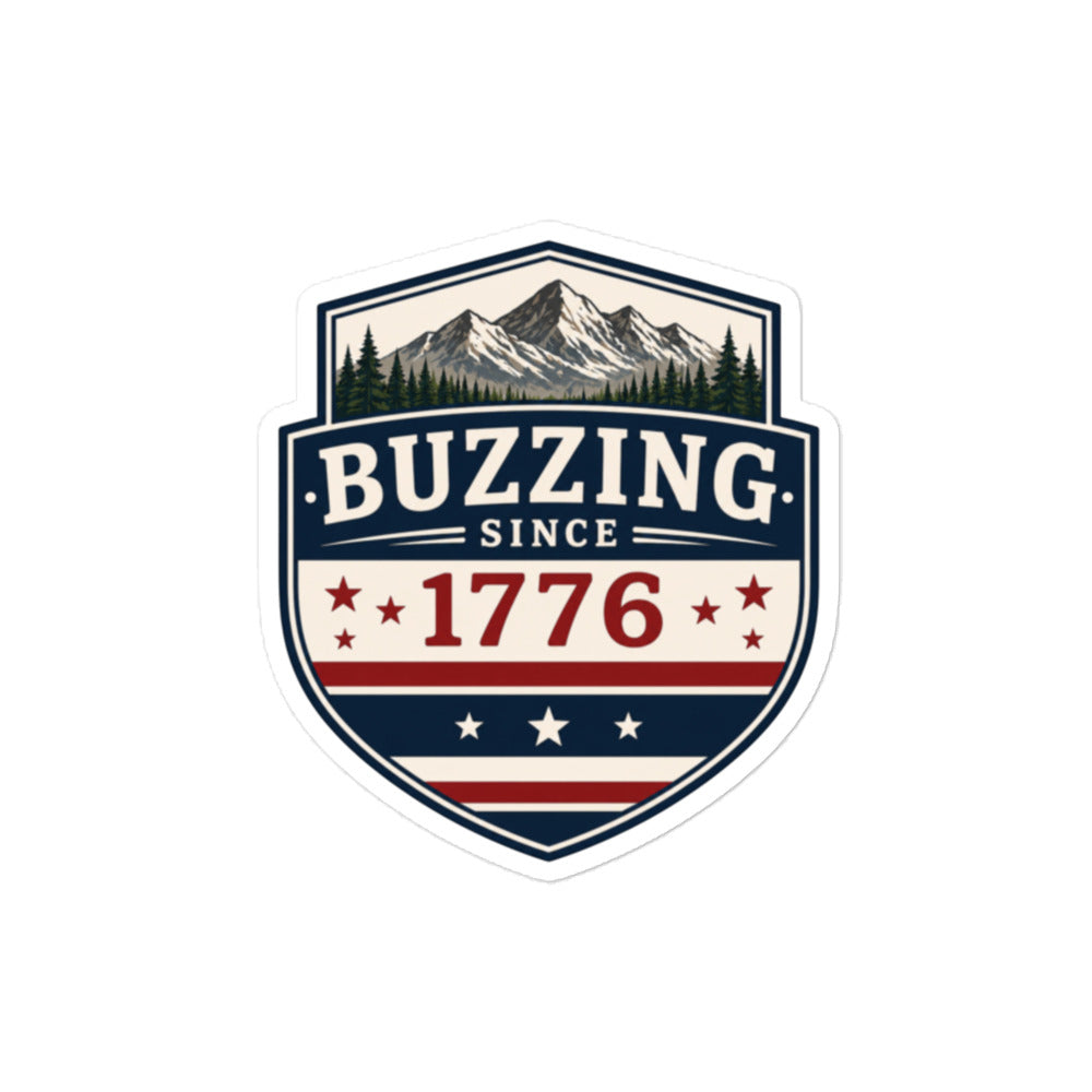 Shield badge sticker with 'BUZZING' text, mountain peaks, trees, and star-spangled stripes.