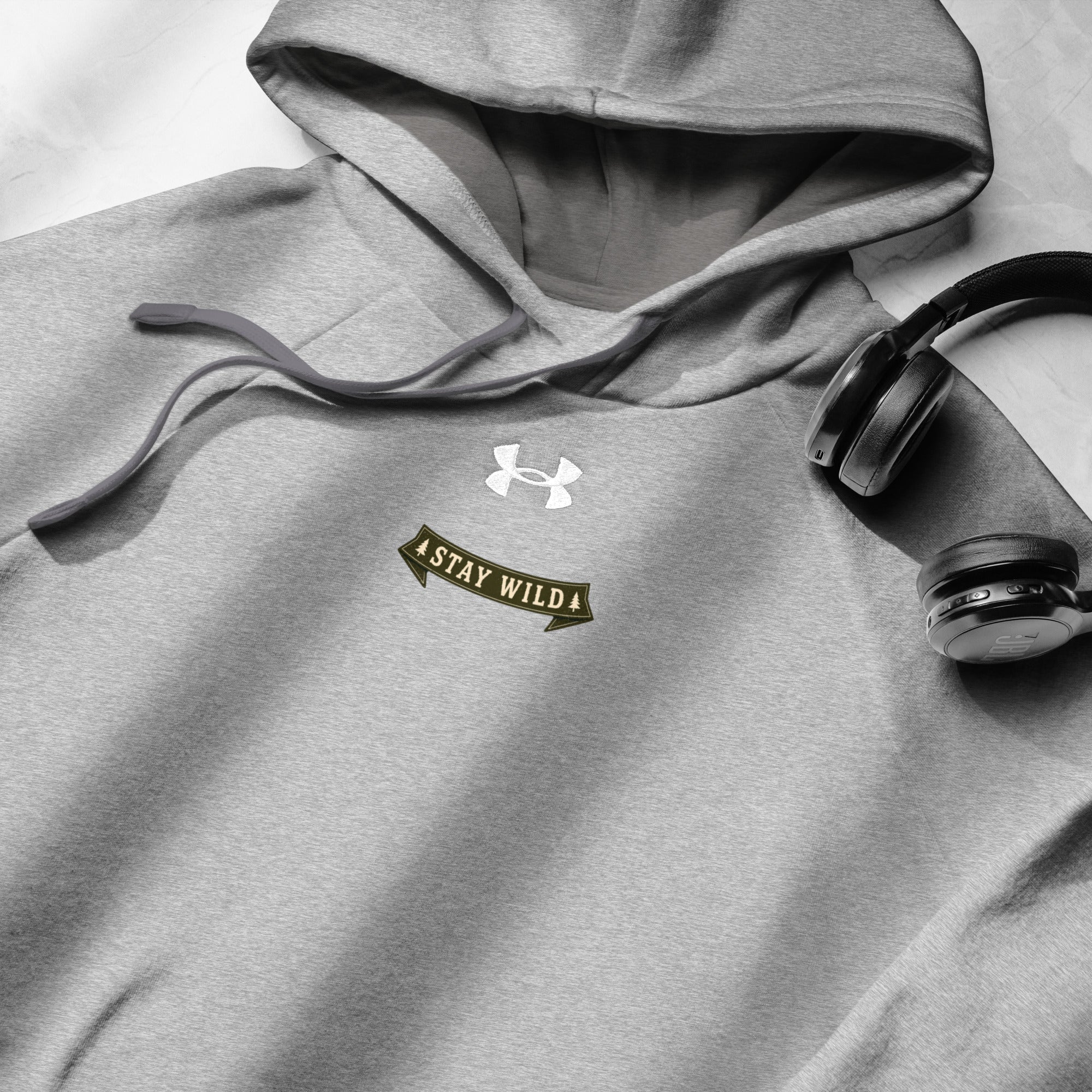 Gray Under Armour hoodie with chest logo and "Stay Wild" badge