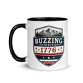 Two-tone coffee mug with black interior and handle, featuring mountain shield logo.