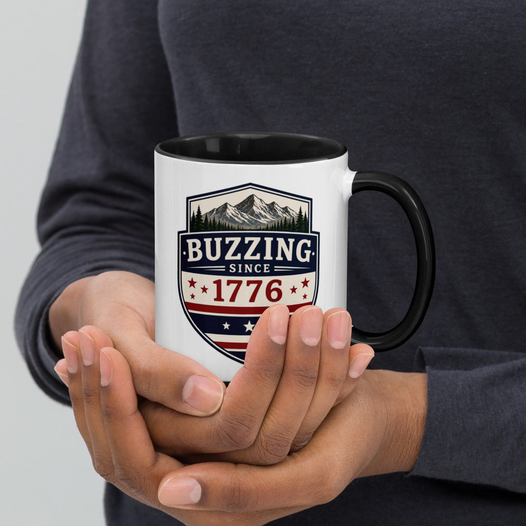White mug with “Buzzing since 1776” graphic, black interior and handle.