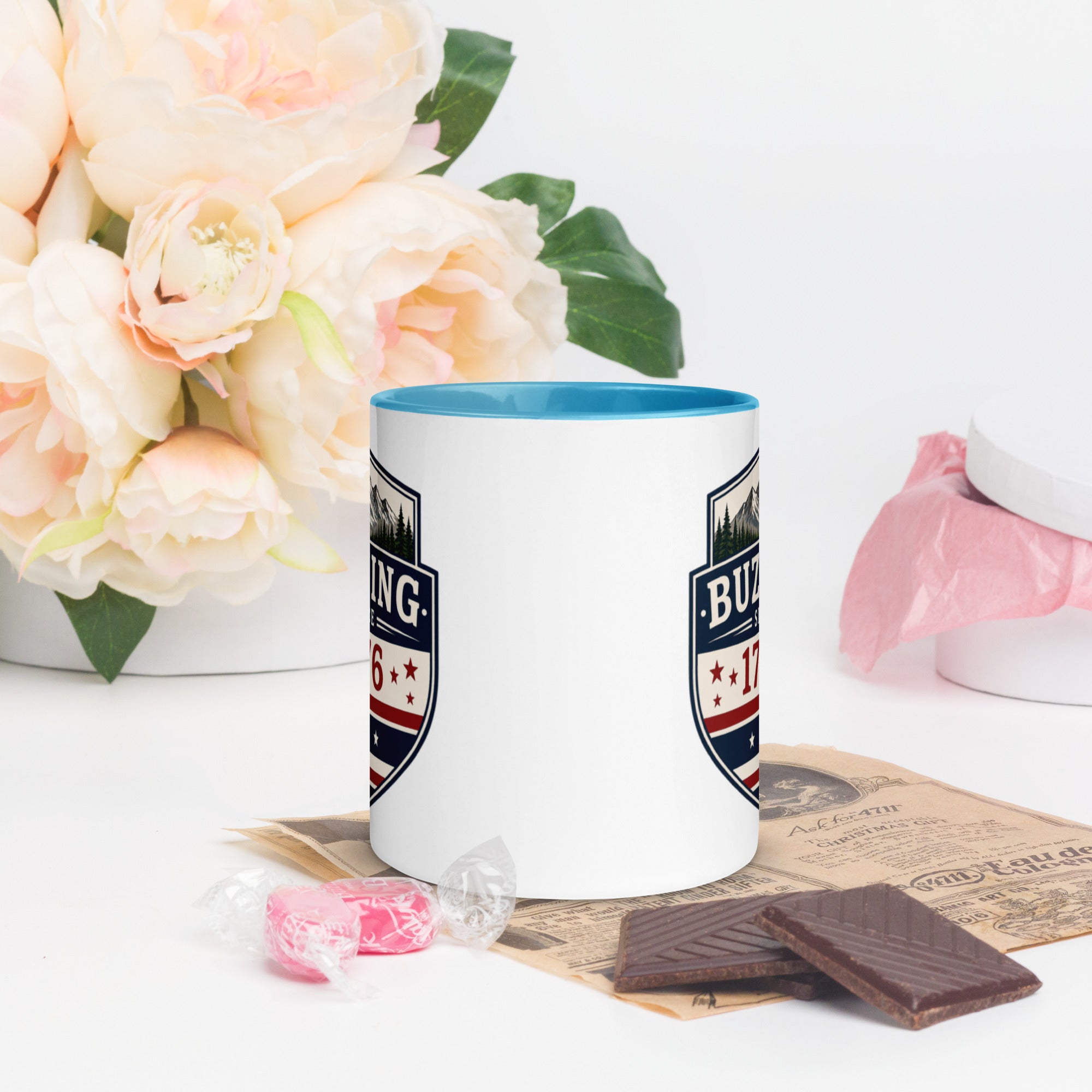 Color-inside ceramic mug with printed shield; blue interior rim.