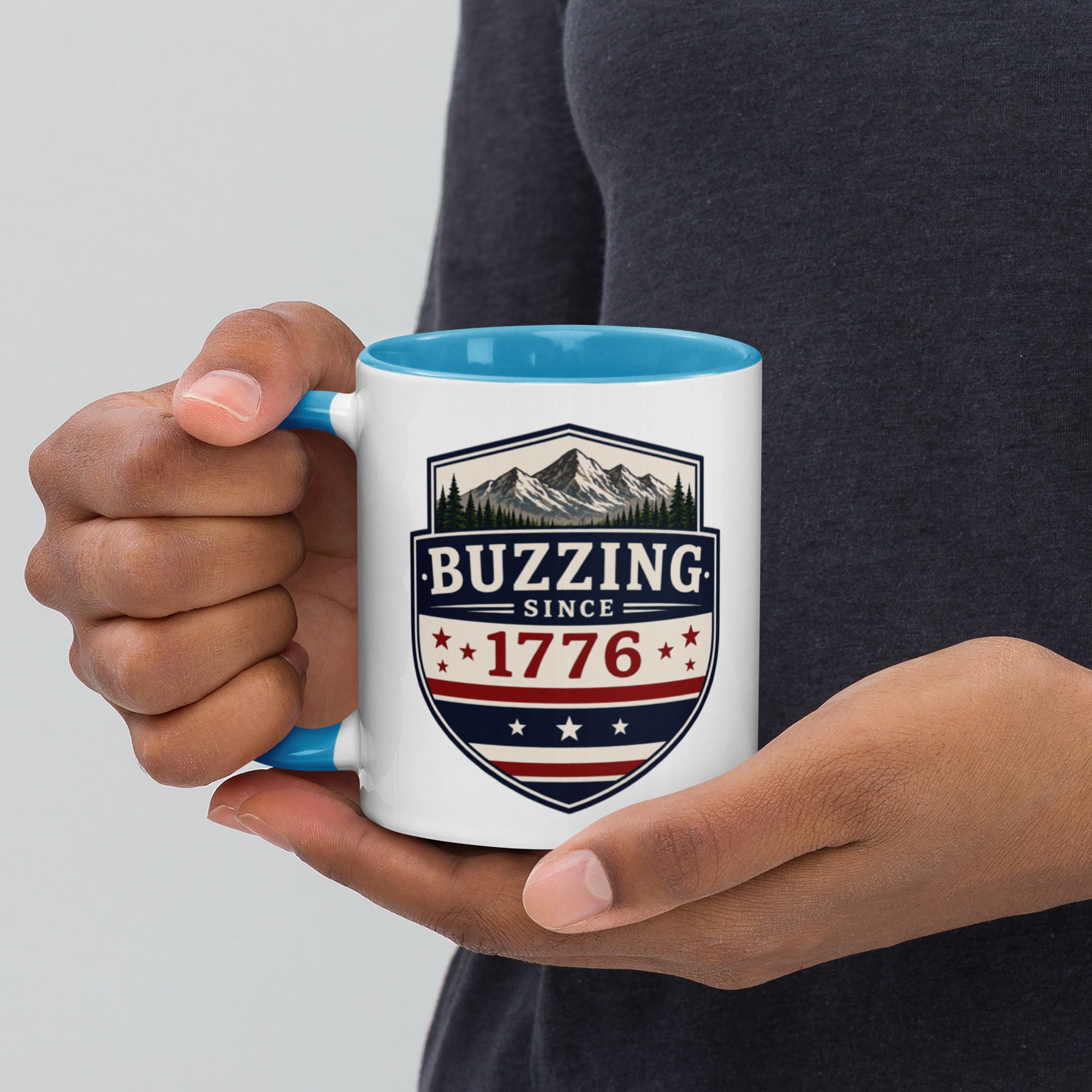 White ceramic mug with blue interior, “Buzzing” 1776 crest graphic