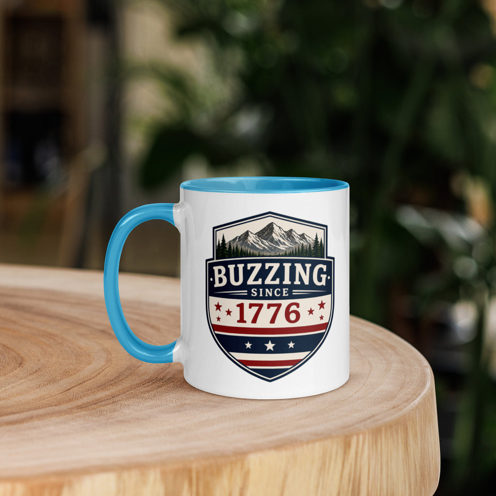 Mug with 'Buzzing Since 1776' crest, white body with blue handle and rim