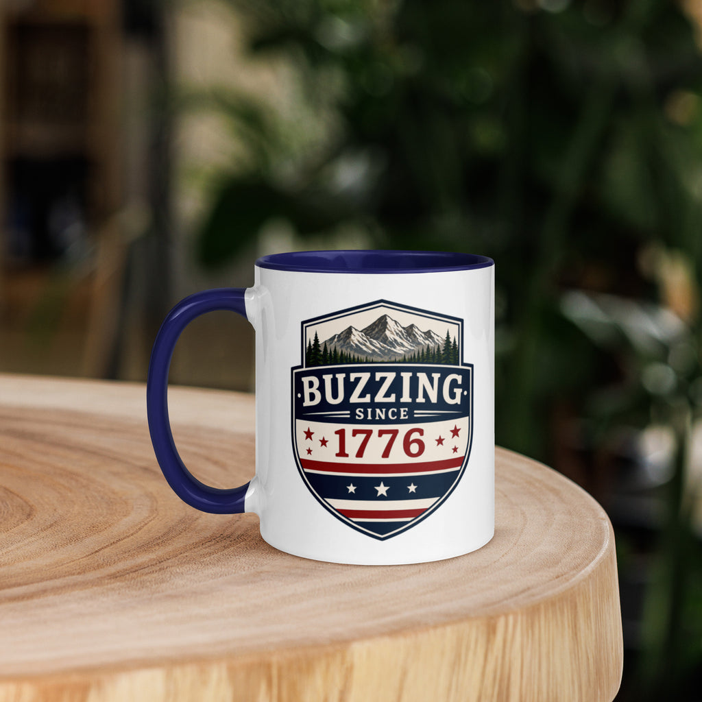 Mug with 'Buzzing Since 1776' crest, white body with dark blue handle and rim