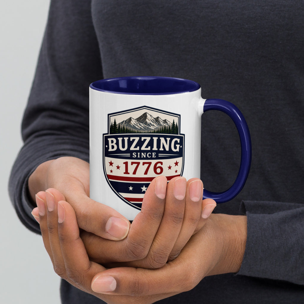 White mug with “Buzzing since 1776” graphic, dark blue interior and handle.